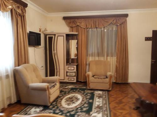 a living room with two chairs and a mirror at Hotel Noy in Goris