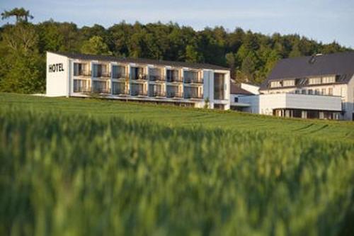 a large building in front of a field of grass at Hotel St Elisabeth in Allensbach