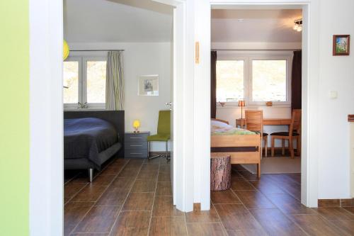 a bedroom with a bed and a dining room at Hainhof Gaestewohnungen in Bad König