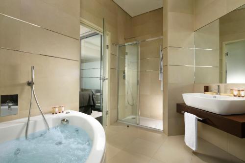 y baño con bañera, lavamanos y ducha. en Hotel La Favorita, en Mantua
