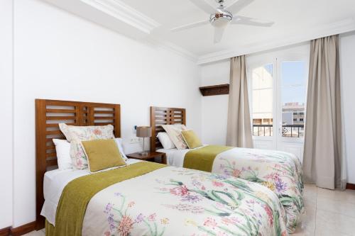 1 dormitorio con 2 camas y ventana en Rooms & Suites Balcony 3C, en Arrecife