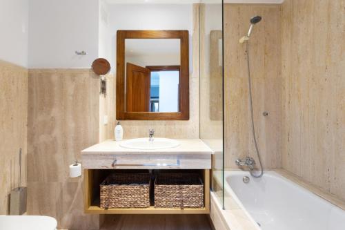een badkamer met een wastafel, een spiegel en een bad bij Rooms & Suites Balcony 3C in Arrecife