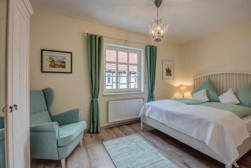 ein Schlafzimmer mit einem Bett, einem Stuhl und einem Fenster in der Unterkunft Ferienhaus Christina in Reichensachsen