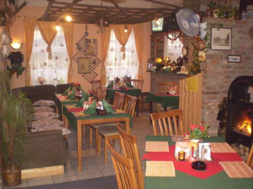 a restaurant with tables and chairs and a fireplace at Pension a Restaurant VESNA - České Švýcarsko in Srbská Kamenice
