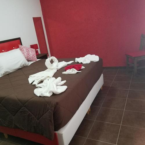 a hotel room with a bed with towels on it at Complejo Los Cipreses in Villa Carlos Paz
