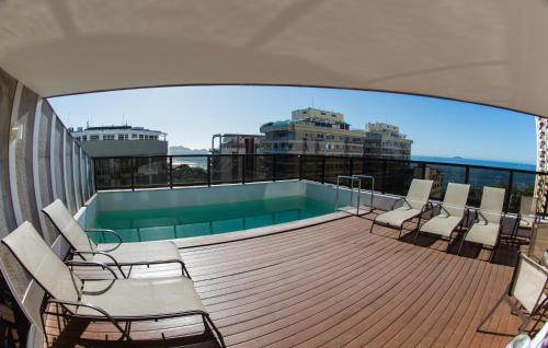 a balcony with chairs and a swimming pool on a building at B&B Hotels Rio Copacabana Forte in Rio de Janeiro