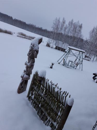 a fence covered in snow next to a playground at Sodyba Vieversynė in Duokiškis