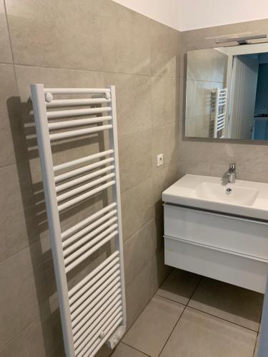 ein Bad mit einem Waschbecken und einem Spiegel in der Unterkunft Studio les pieds dans l'eau Plage du Trottel in Ajaccio