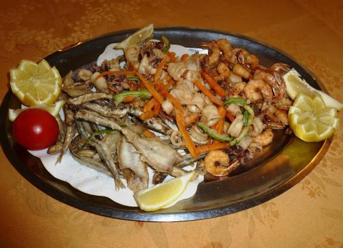 a plate of food with shrimp and lemon slices at Hotel Imperiale in Cesenatico