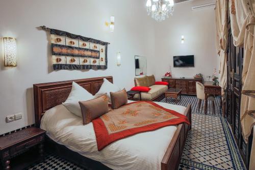 a bedroom with a bed and a living room at Le Grand Alcazar - Riad in Fès