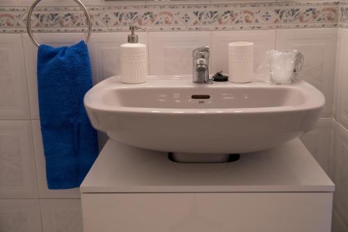 a white sink in a bathroom with a blue towel at Apartamento Punta de Torrox in Torrox