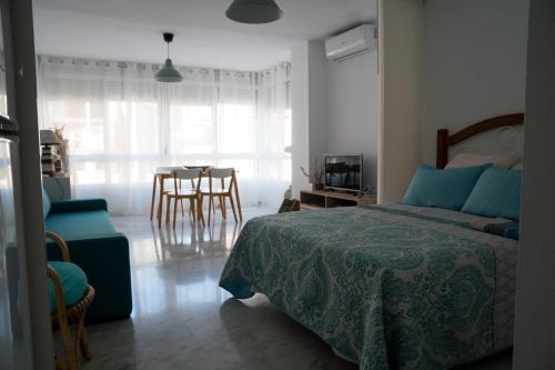 a bedroom with a bed and a table and chairs at Apartamento Punta de Torrox in Torrox
