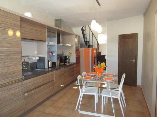 une salle à manger avec une table en verre et des chaises blanches dans l'établissement WELCOME Bayeux, à Bayeux