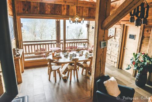a dining room with a table and chairs in a cabin at La grange d'Aldaré Chambres d'hôtes in Combloux