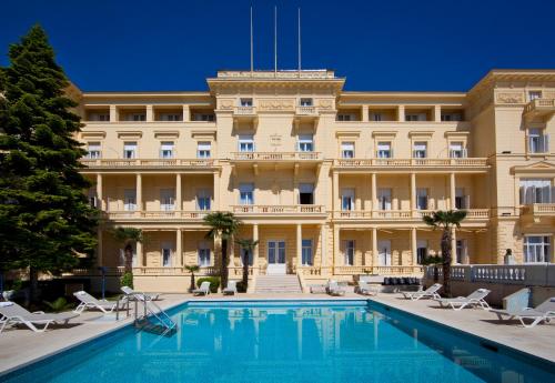 een hotel met een zwembad voor een gebouw bij Hotel Kvarner - Liburnia in Opatija