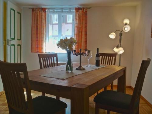 a dining room table with a vase of flowers on it at Grüne Franziska in Ettenheim