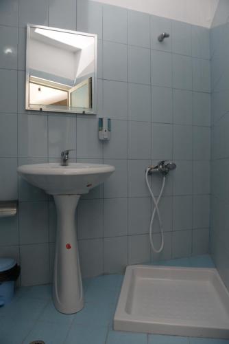 a white bathroom with a sink and a mirror at Guest House Taunus in Berat