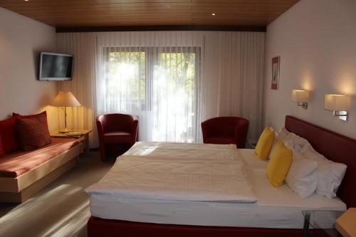 a hotel room with a bed and a window at Hotel Rebstock in Ohlsbach