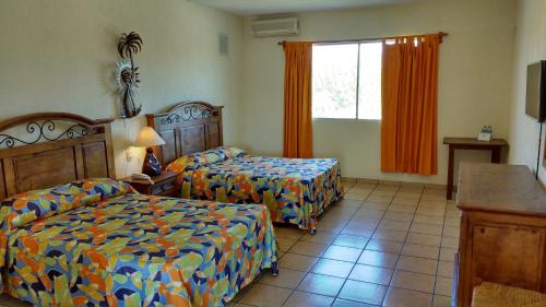 Voodi või voodid majutusasutuse Hotel Hacienda Bugambilias toas