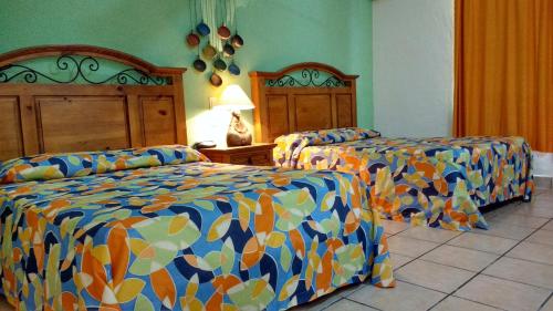 Cama o camas de una habitación en Hotel Hacienda Bugambilias