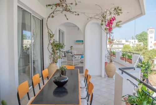 a dining room with a table and chairs on a balcony at Casa Bianca - Good Living in Preveza