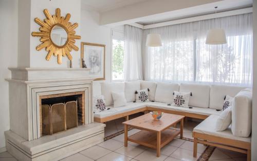 a living room with a white couch and a fireplace at Casa Bianca - Good Living in Preveza