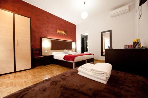a bedroom with two beds and a red wall at Star of Rome in Rome