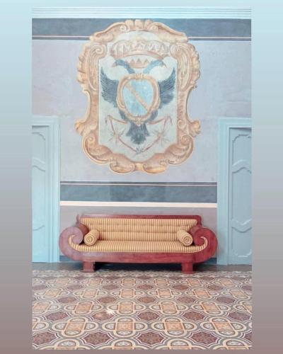 a couch in a room with a picture on the wall at Dimora Duchessina Suites de Charme in Minervino di Lecce