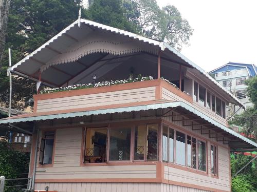 a house with a balcony on top of it at Little Singamari Home Stay in Darjeeling