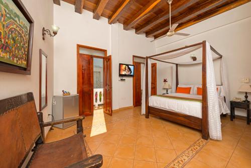 ein Schlafzimmer mit einem Bett und einem Stuhl in einem Zimmer in der Unterkunft Casa Del Curato in Cartagena de Indias