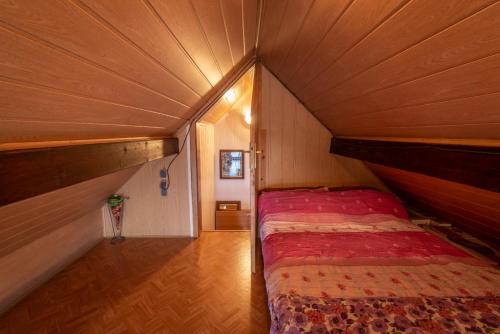 a small bedroom with a bed in a wooden room at Vineyard cottage Hočevar in Novo Mesto