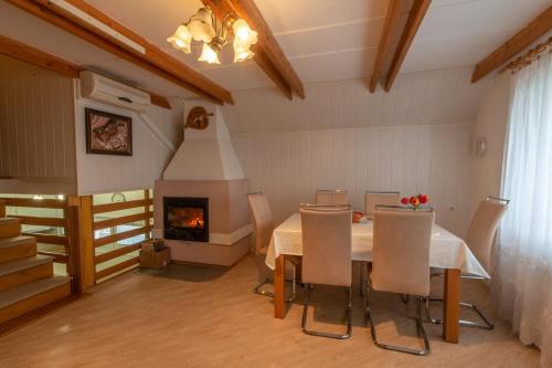 a dining room with a table and a fireplace at Vineyard cottage Hočevar in Novo Mesto
