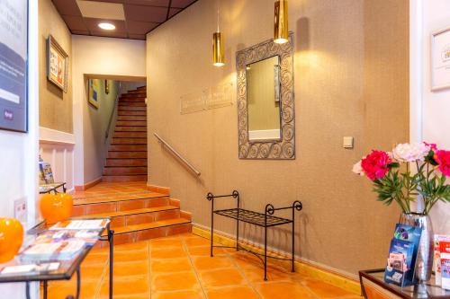 a hallway with stairs and a mirror on the wall at Kyriad Avignon - Palais des Papes in Avignon