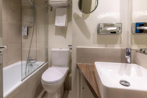 a bathroom with a white toilet and a sink at Kyriad Avignon - Palais des Papes in Avignon