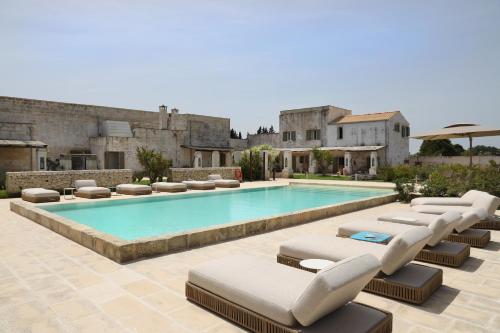 una piscina con tumbonas y una piscina en Borgo Sentinella, en Torre dell'Orso