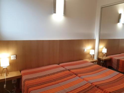 a hotel room with two beds and a mirror at Résidence les Hameaux de Bocca del Oro in Porto-Vecchio