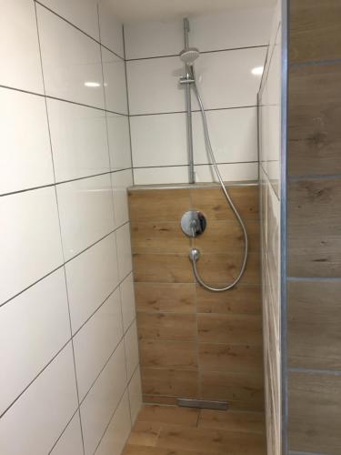a shower in a bathroom with white tiles at Ferienwohnung Reh in Bad Rappenau