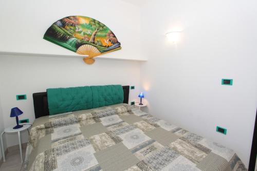 a bedroom with a bed with a green head board at Residence Vives in Comacchio