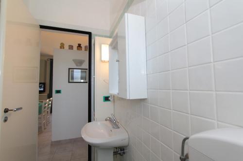 a white bathroom with a sink and a mirror at Residence Vives in Comacchio