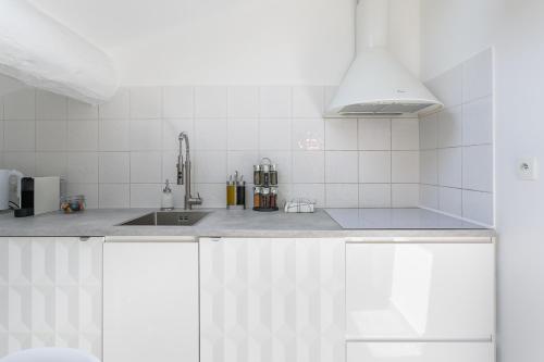 a white kitchen with a sink and a counter at My Pad Provence 5 in Avignon