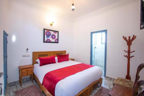 a bedroom with a large bed with red pillows at Cine House in Fès