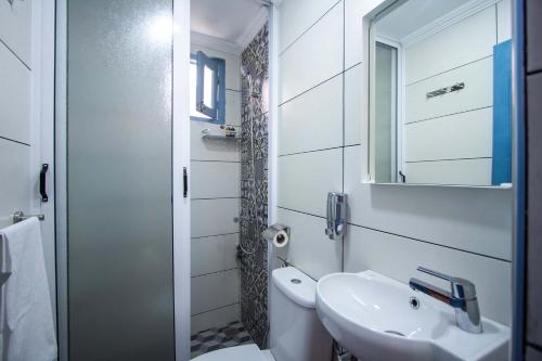 ein weißes Badezimmer mit einem Waschbecken und einem Spiegel in der Unterkunft Cine House in Fès