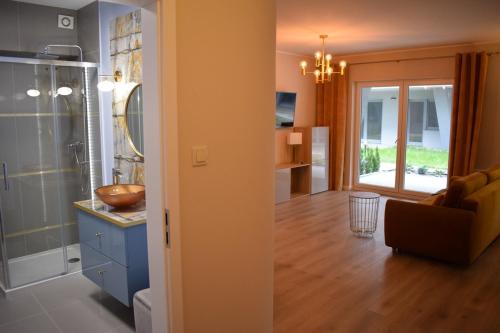 a room with a kitchen and a living room at Apartament Silence Gold Club in Pobierowo