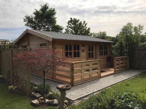 a log cabin with a deck and a fence at The Cabin in Chester