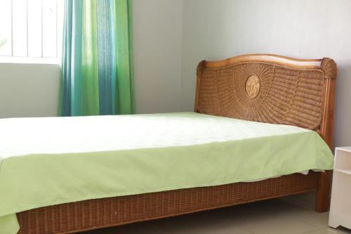 a wicker bed with a white mattress and a window at Le Grand Cacatoie in Blue Bay