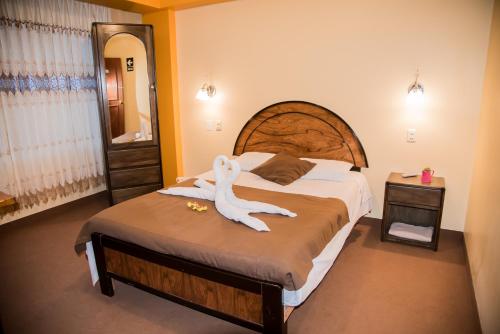 Un dormitorio con una cama grande con un animal blanco. en HOSTAL MILAGROS INN - samary inn, en Puno