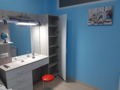 un bagno con un lavandino e uno sgabello rosso di МАТЕ Apartment a Batumi