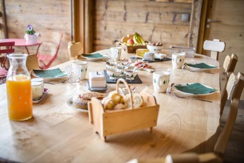 a wooden table with food and orange juice on it at La grange d'Aldaré Chambres d'hôtes in Combloux