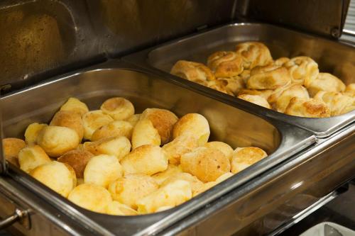 een stapel broodjes in bakplaten in een oven bij Villa Bella Hotel & SPA Gramado in Gramado