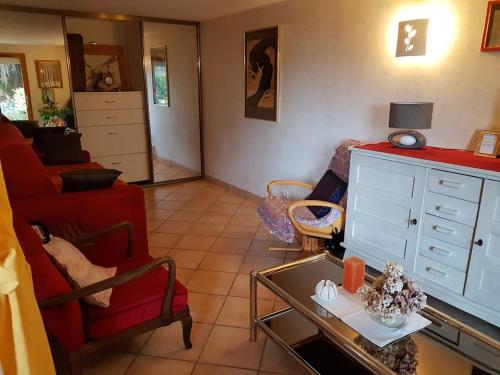 - un salon avec un canapé rouge et un fauteuil rouge dans l'établissement LE ROSSIGNOL, à Cranves-Sales